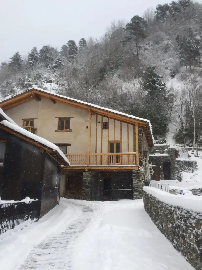 Façana de Cal Batlle nevada a l'hivern, amb el camí d'accés