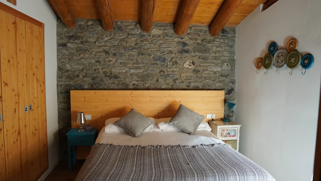 Habitació 5 amb llit doble i paret de pedra