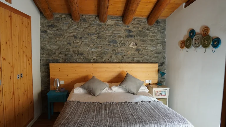Habitació 5 amb llit doble i paret de pedra
