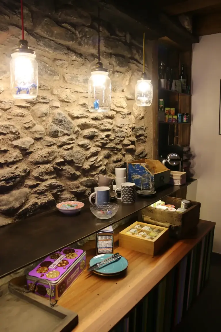 Racó de cafè i infusions amb llums penjants davant la paret de pedra