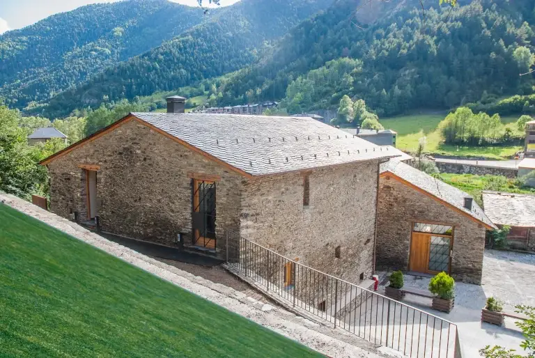 Cal Batlle des de dalt, amb teulada de llicorella i la vall d'Ordino al fons